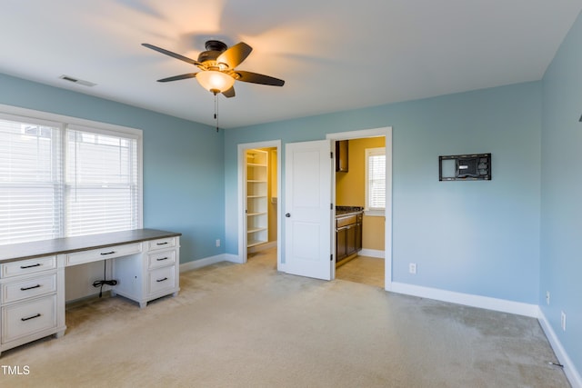 unfurnished office with ceiling fan and light colored carpet