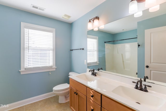 bathroom featuring vanity, toilet, tile patterned floors, and walk in shower