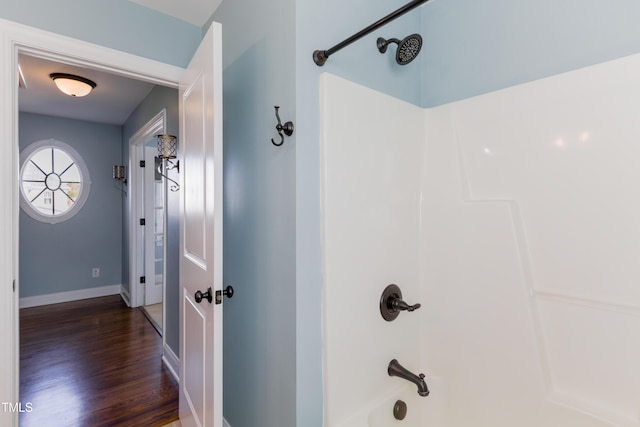 bathroom featuring washtub / shower combination and hardwood / wood-style floors