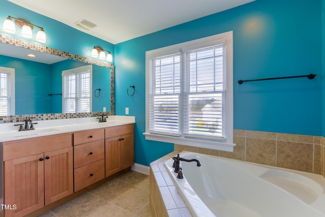 bathroom featuring vanity, a relaxing tiled tub, and tile patterned floors