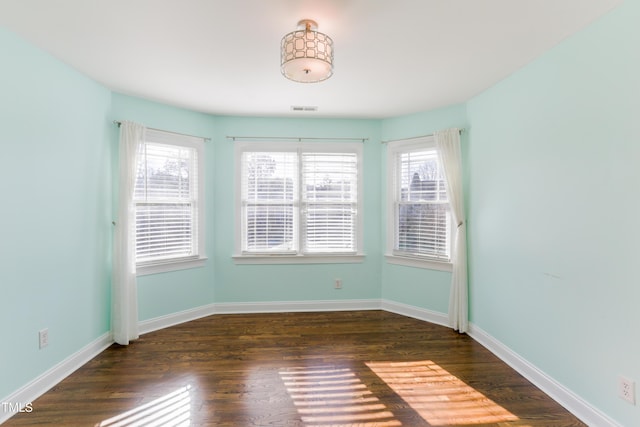 unfurnished room with dark wood-type flooring