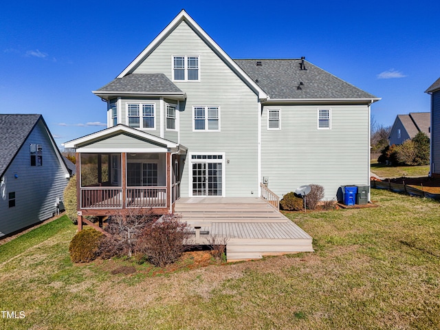 back of house featuring a yard, a deck, and a sunroom