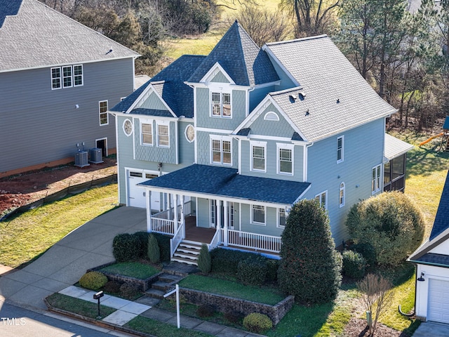 view of front of home with a front lawn, central AC, a garage, and a porch