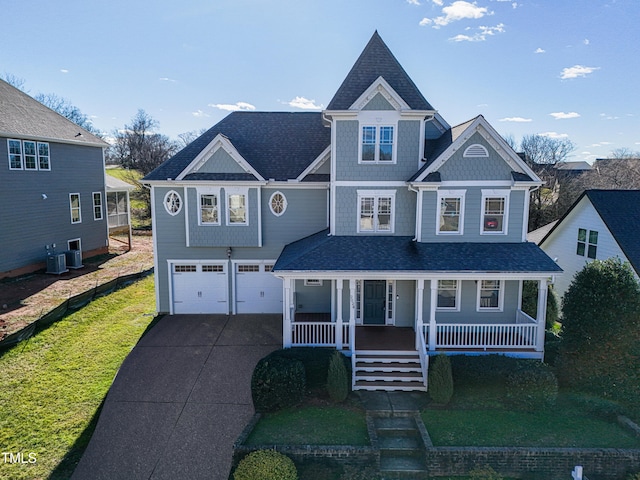 view of front facade featuring central AC, covered porch, a front lawn, and a garage