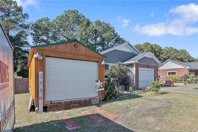 view of front of property with a front yard, a garage, and an outbuilding