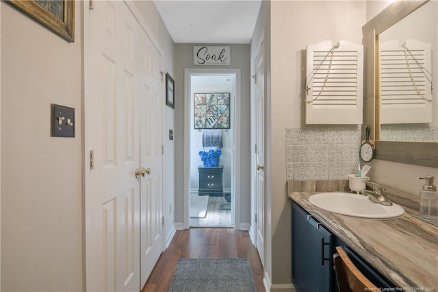 bathroom with vanity, baseboards, and wood finished floors