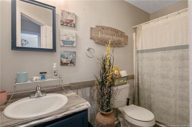 full bath featuring toilet, a shower with curtain, and vanity