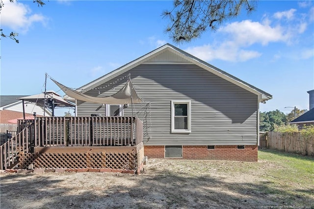 back of property featuring fence and a wooden deck