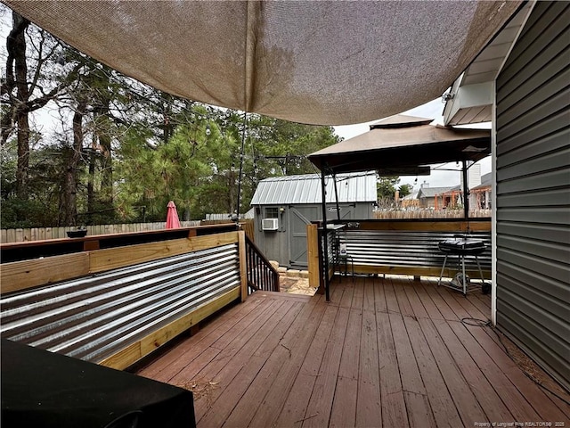 wooden terrace with a storage shed, a fenced backyard, and an outdoor structure