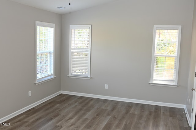 unfurnished room with dark hardwood / wood-style floors, a healthy amount of sunlight, and lofted ceiling