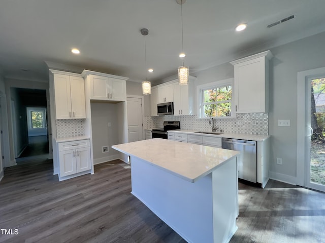 2710-A Mansfield Ave, Durham, NC 27703 - kitchen featuring appliances with stainless steel finishes, a sink, white cabinetry, decorative backsplash, and light countertops