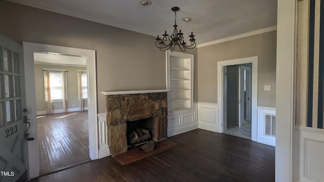 unfurnished living room with a notable chandelier, crown molding, a fireplace, and dark hardwood / wood-style floors