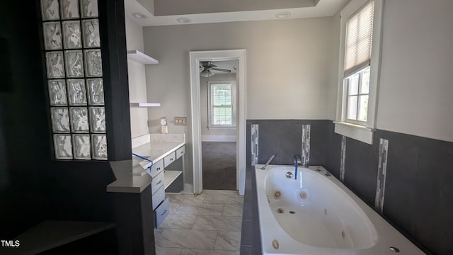 bathroom with vanity, a tub to relax in, and ceiling fan