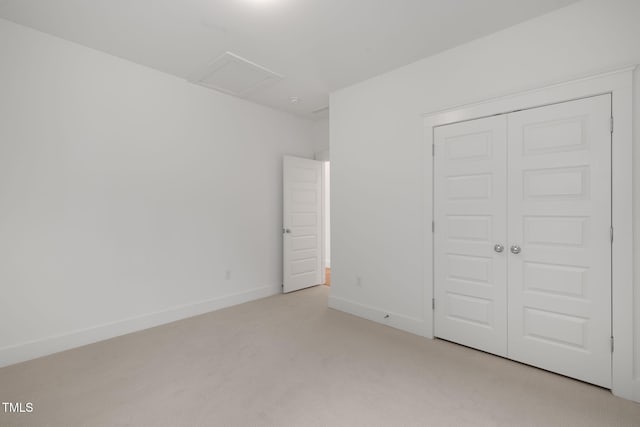 unfurnished bedroom featuring light carpet and a closet