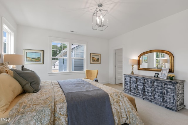 carpeted bedroom with a notable chandelier and multiple windows