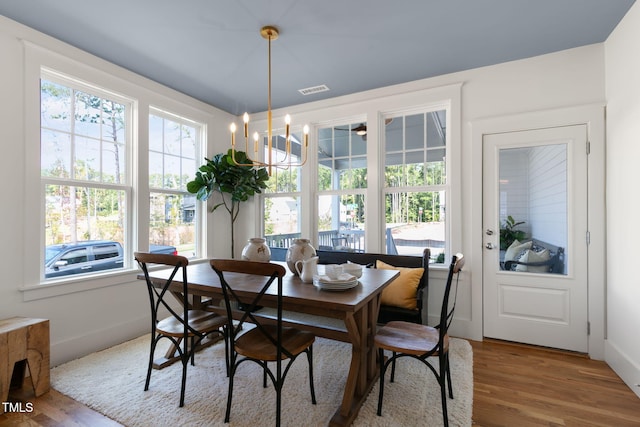 dining area with hardwood / wood-style flooring and a chandelier