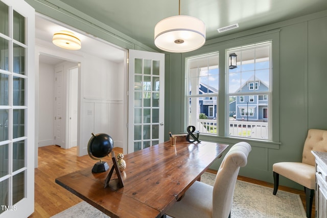 dining area with french doors and light hardwood / wood-style flooring