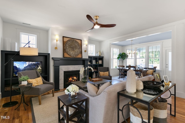 living room with light hardwood / wood-style flooring, ceiling fan, and a wealth of natural light