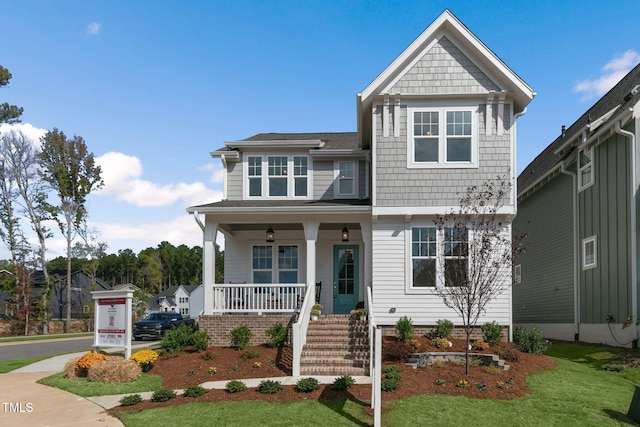 view of front facade featuring covered porch and a front lawn