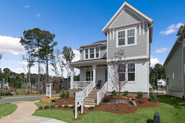 view of front of home with a porch and a front lawn