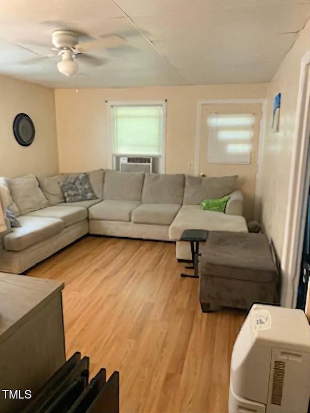 living room with ceiling fan, cooling unit, and light hardwood / wood-style flooring