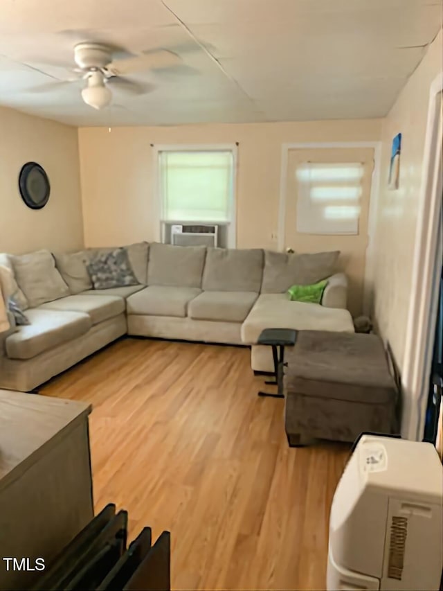 living area with cooling unit, light wood-style flooring, and ceiling fan