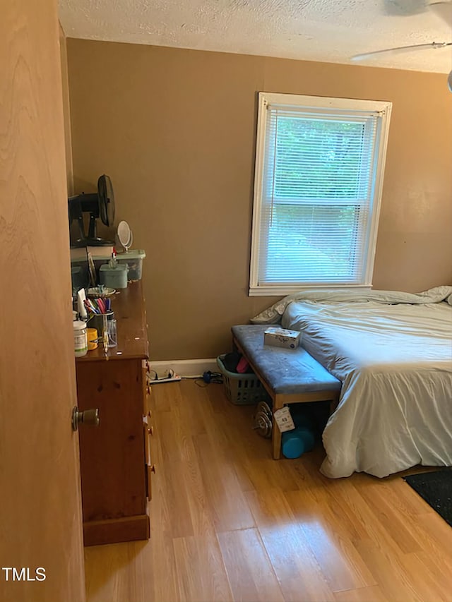 bedroom with wood finished floors and a textured ceiling