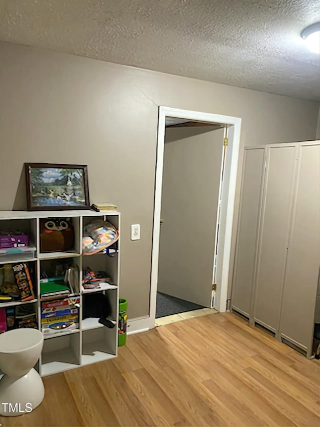rec room with wood finished floors and a textured ceiling