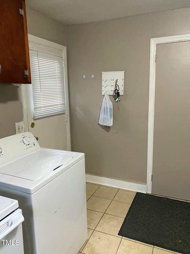 laundry area with washer / dryer and light tile patterned floors