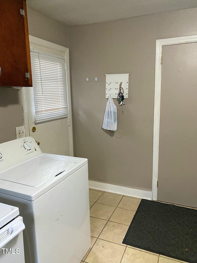 washroom with washer / clothes dryer, light tile patterned floors, and baseboards