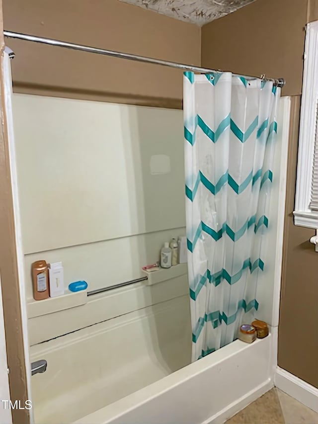 bathroom featuring shower / bath combo with shower curtain and tile patterned flooring