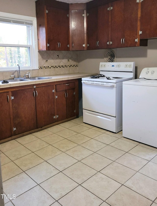 kitchen featuring dark brown cabinets, sink, white range with electric stovetop, and independent washer and dryer