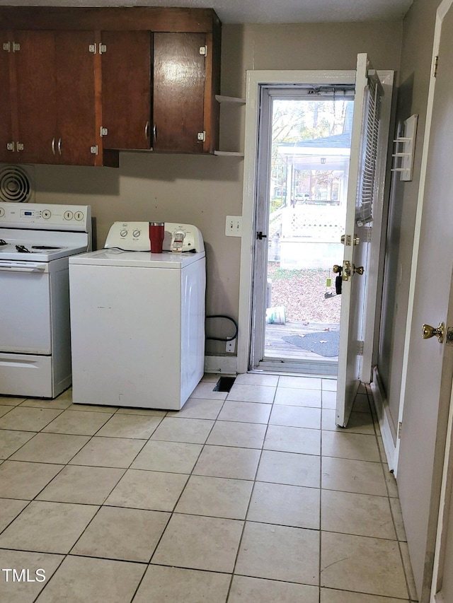 washroom with washer / clothes dryer and light tile patterned floors