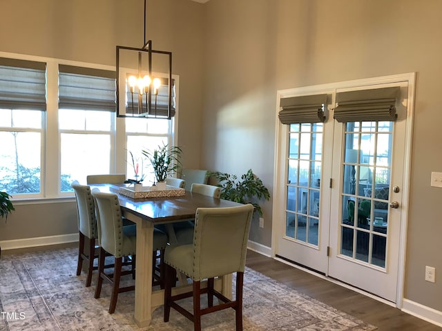 dining room featuring a wealth of natural light, dark wood-type flooring, and a notable chandelier