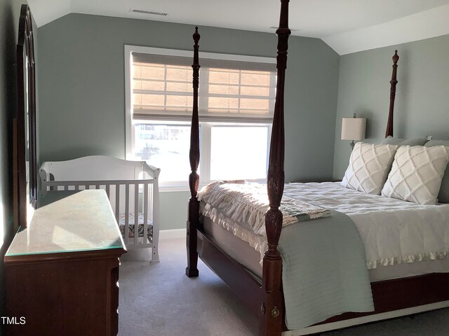 carpeted bedroom with lofted ceiling