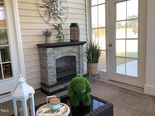 carpeted living room with wooden walls and a fireplace