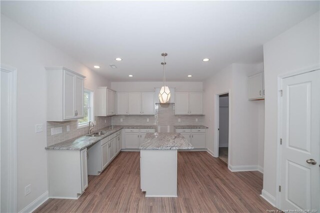 kitchen featuring hardwood / wood-style floors, a center island, white cabinetry, and hanging light fixtures