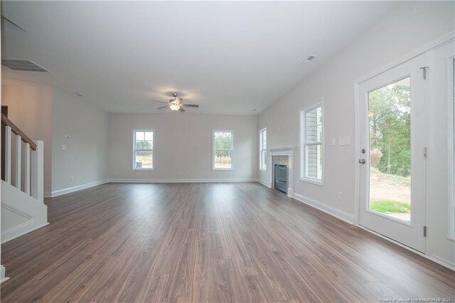 unfurnished living room featuring dark hardwood / wood-style flooring, plenty of natural light, and ceiling fan