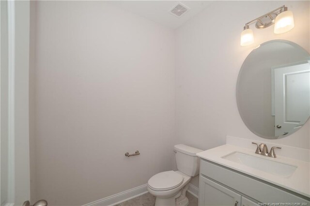 bathroom featuring tile patterned flooring, vanity, and toilet