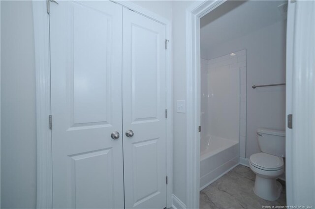 bathroom featuring shower / bathing tub combination and toilet