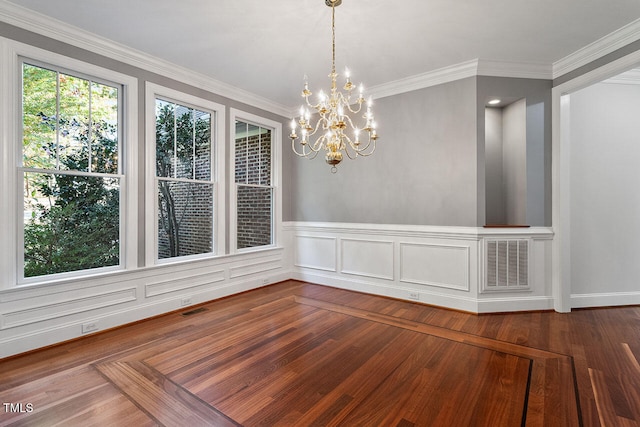 unfurnished dining area with an inviting chandelier, ornamental molding, and hardwood / wood-style flooring