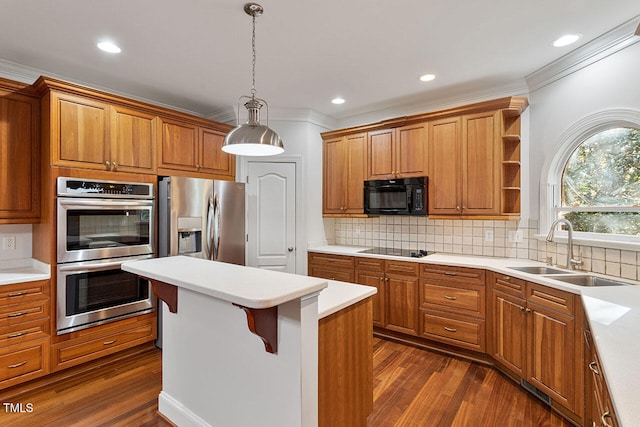 kitchen with black appliances, sink, hanging light fixtures, a breakfast bar, and dark hardwood / wood-style floors