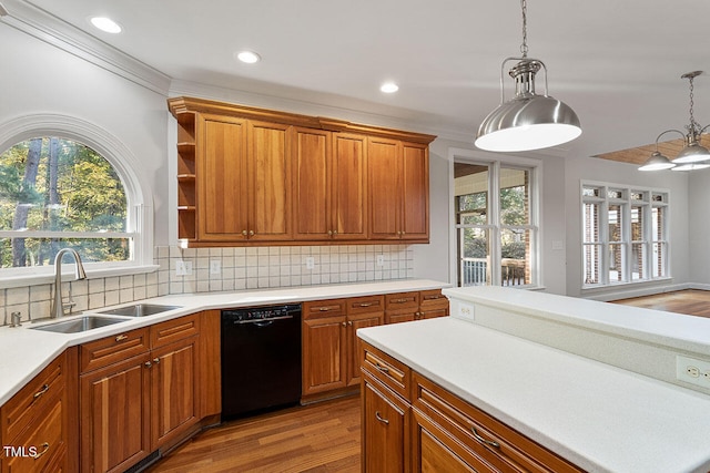 kitchen featuring black dishwasher, sink, light wood-type flooring, decorative light fixtures, and crown molding