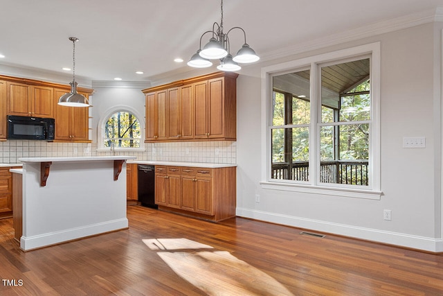 kitchen with a chandelier, wood-type flooring, a kitchen bar, black appliances, and pendant lighting