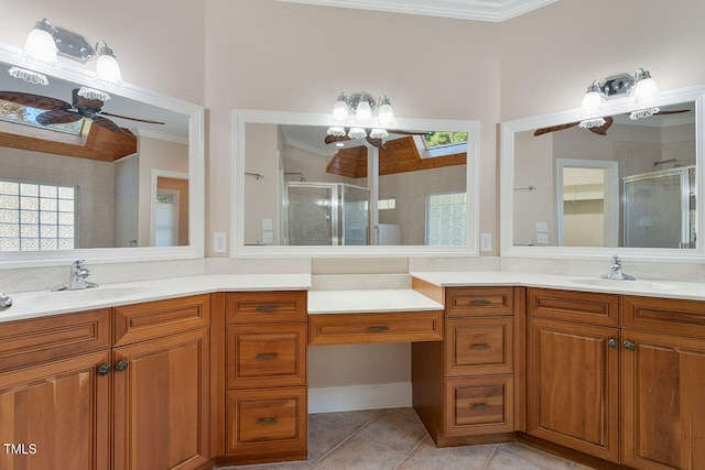 bathroom featuring a shower with door, a skylight, vanity, crown molding, and tile patterned floors