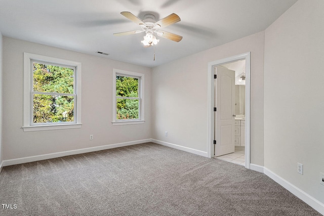 spare room featuring light colored carpet and ceiling fan