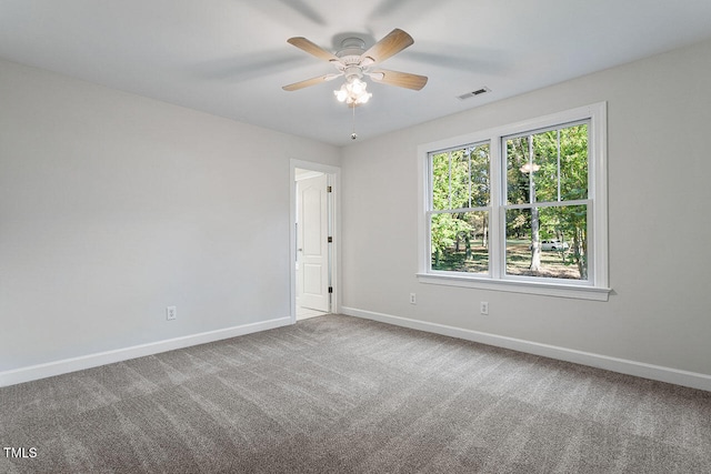 empty room featuring ceiling fan and carpet