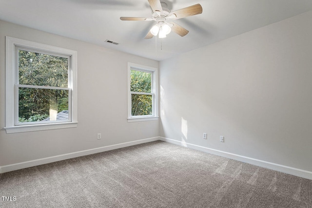 carpeted empty room featuring plenty of natural light and ceiling fan