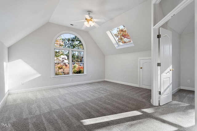 additional living space with lofted ceiling with skylight, carpet flooring, and ceiling fan