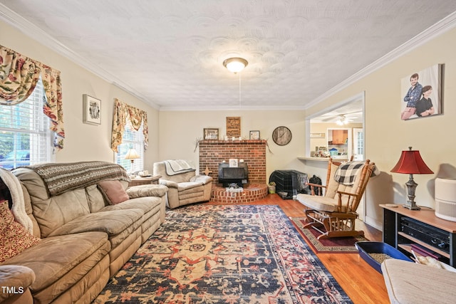 living room with a wood stove, hardwood / wood-style floors, crown molding, a textured ceiling, and ceiling fan